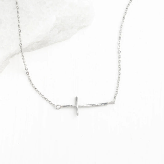 A delicate silver chain necklace featuring a horizontal cross pendant displayed on a light white background.