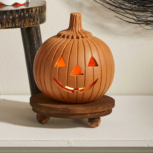 Hand-painted terracotta pumpkin lantern with a classic cutout jack-o’-lantern face.