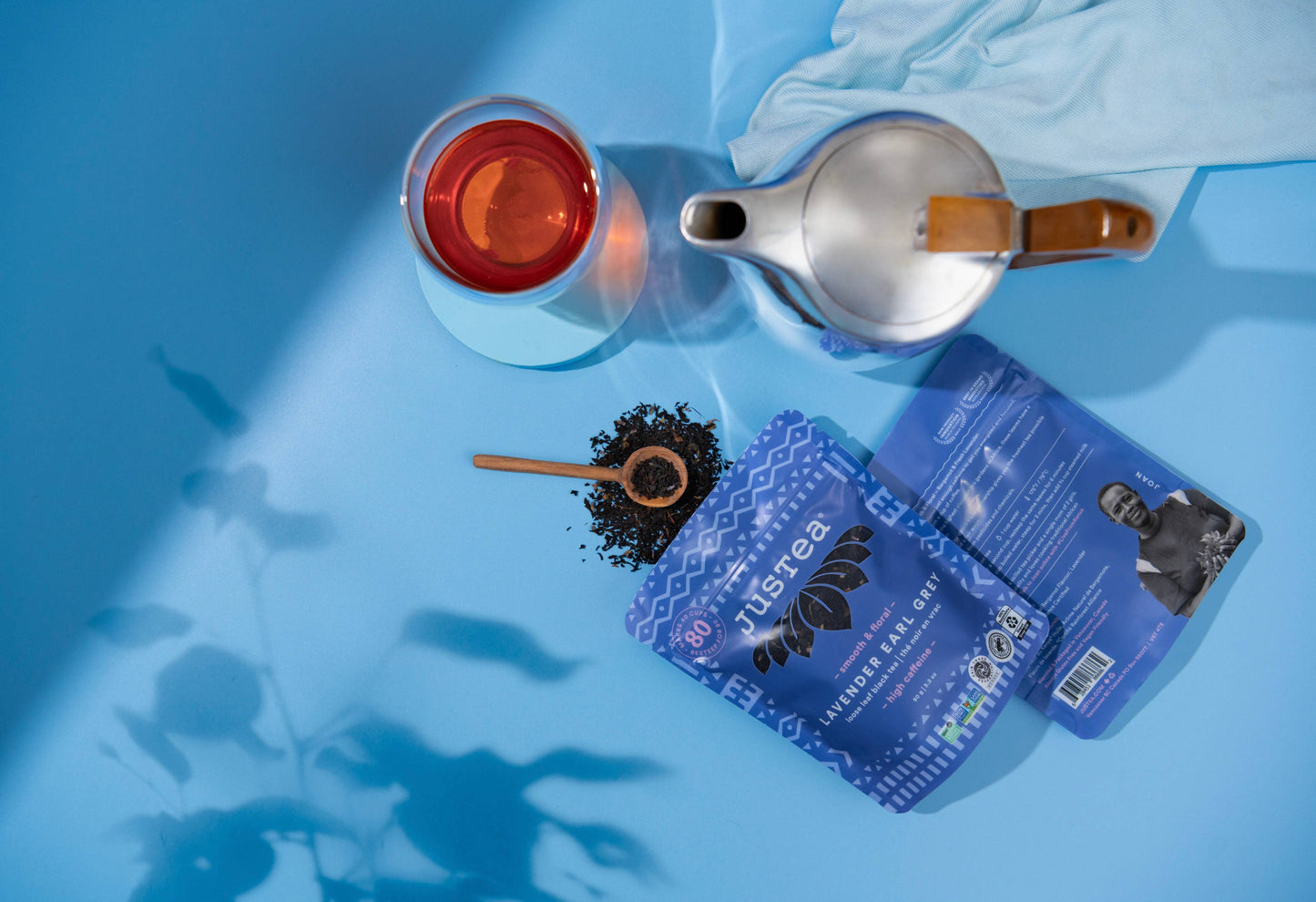 Tea packaging with a teapot and cup on a blue surface