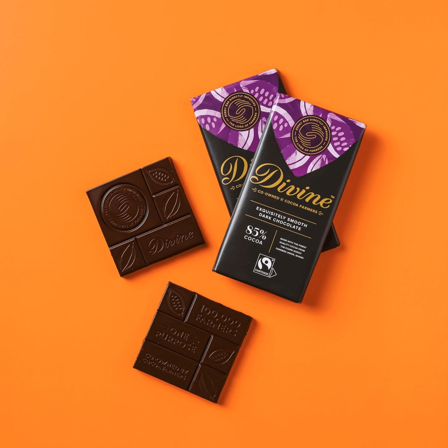 Divine dark chocolate bars with packaging on an orange background