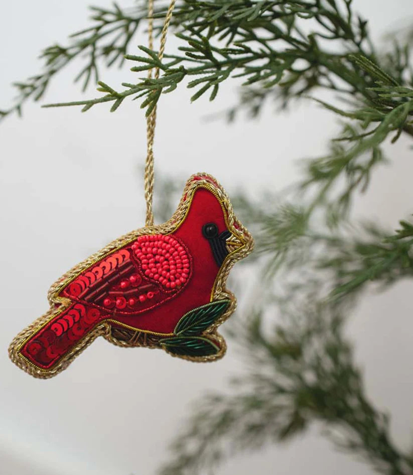 Close-up of a handcrafted red cardinal ornament showing intricate beadwork, sequins and embroidery.