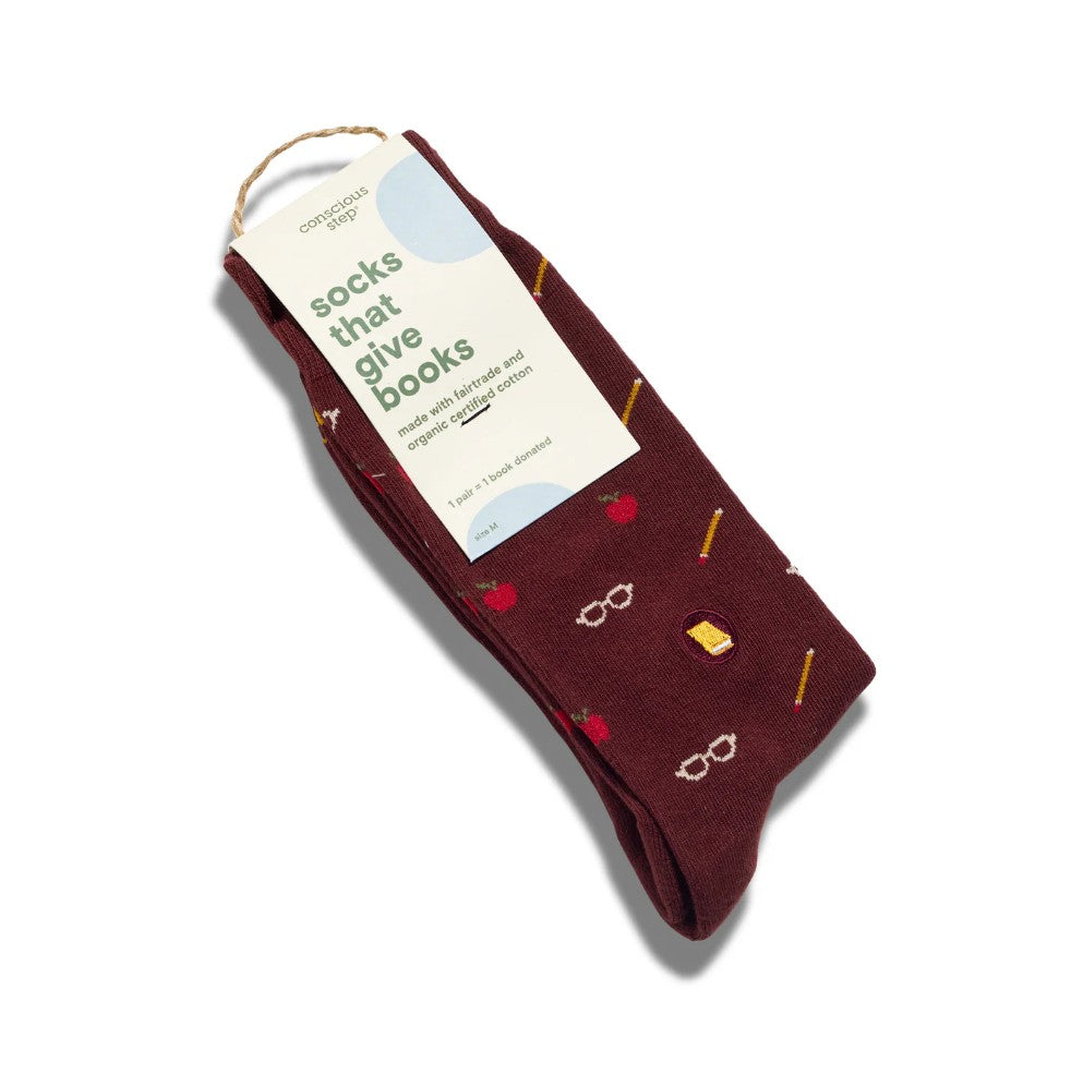 A pair of dark maroon crew socks with a 'socks that give books' novelty pattern, featuring small illustrations of books, glasses, and pencils, complete with a paper hang tag.