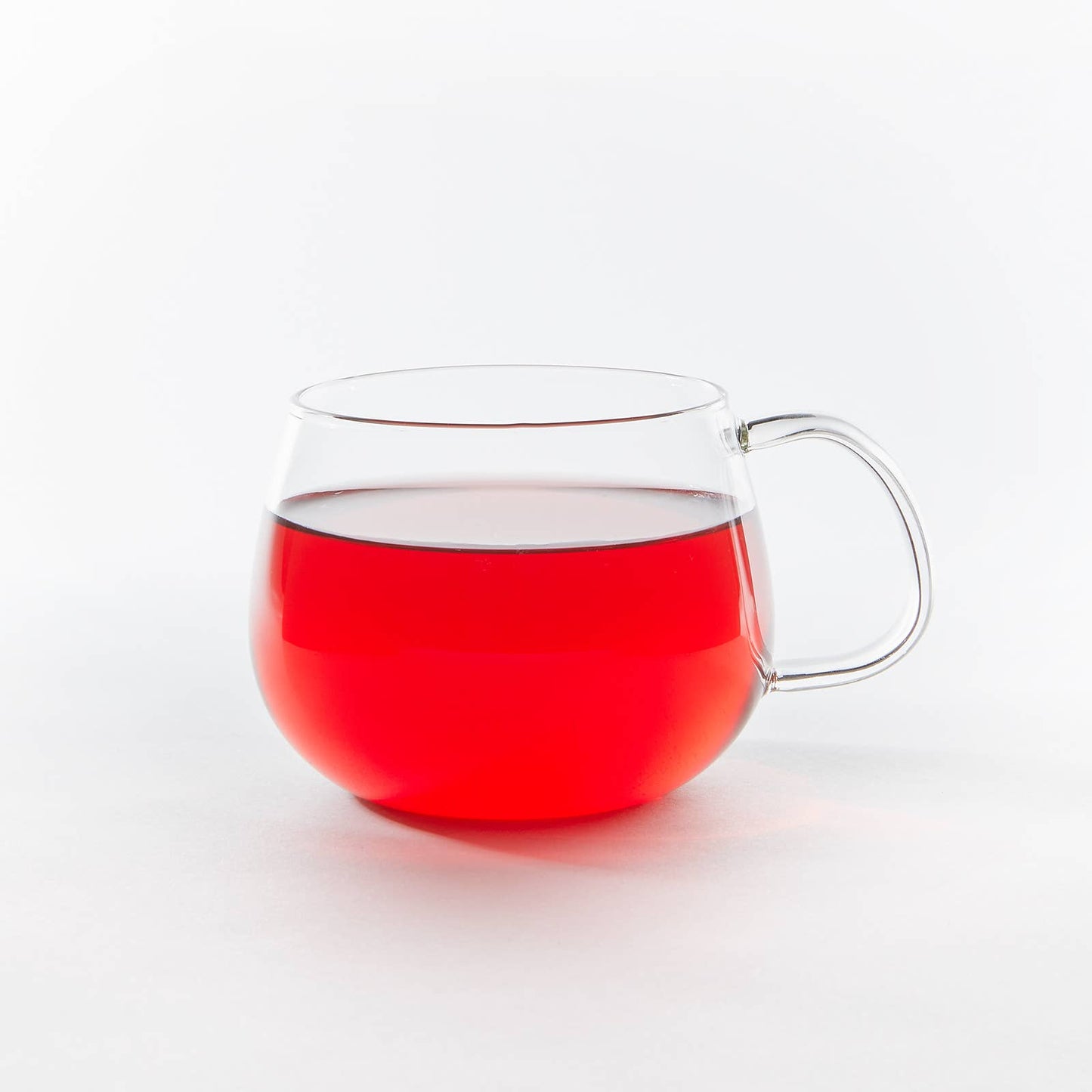 Clear glass mug with a red interior on a white background