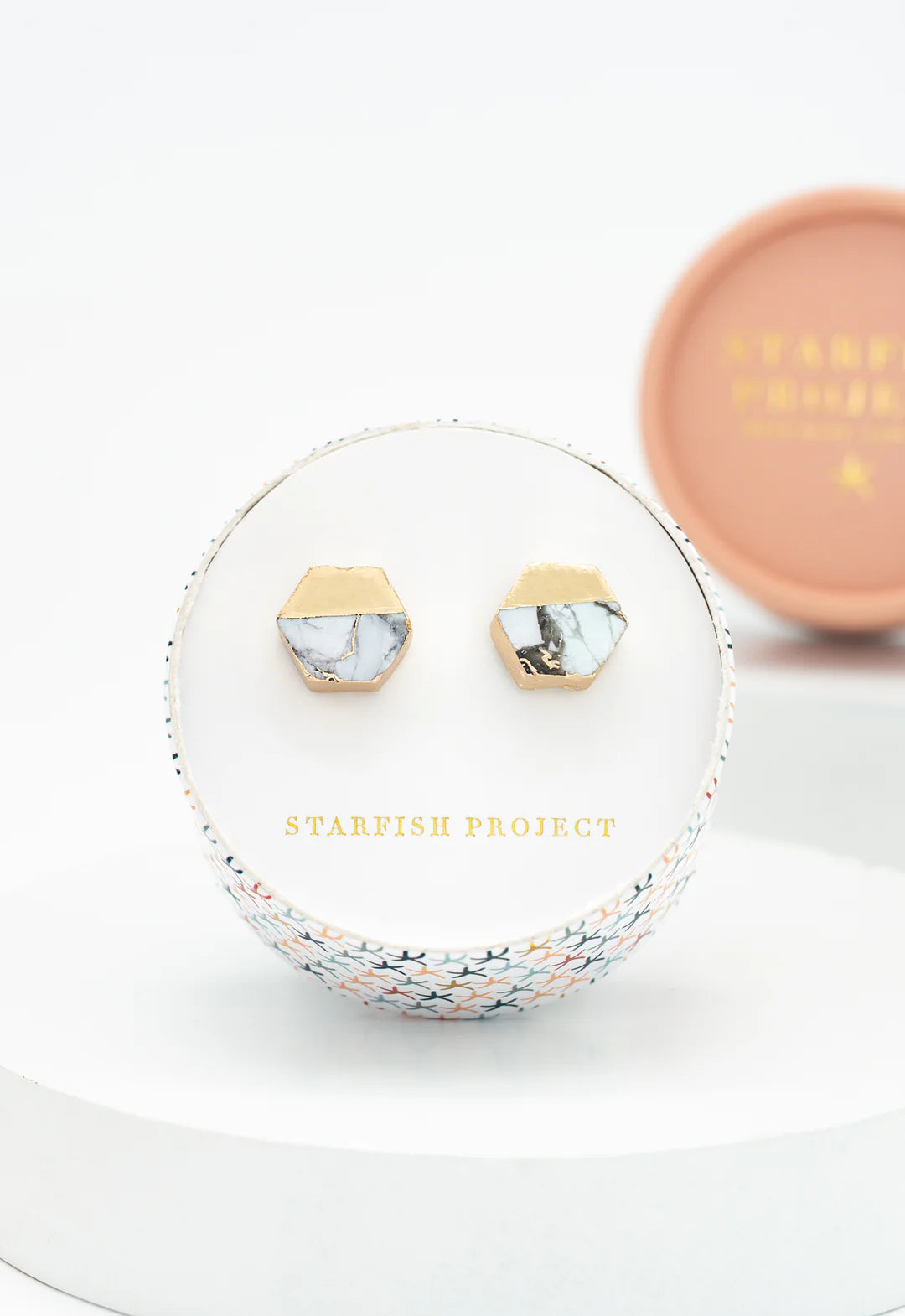 Marble stud earrings in a 'Starfish Project' jewelry box on a white background