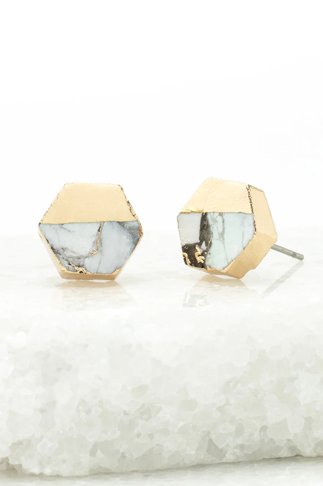 Hexagonal earrings with gold and marble design on a white background