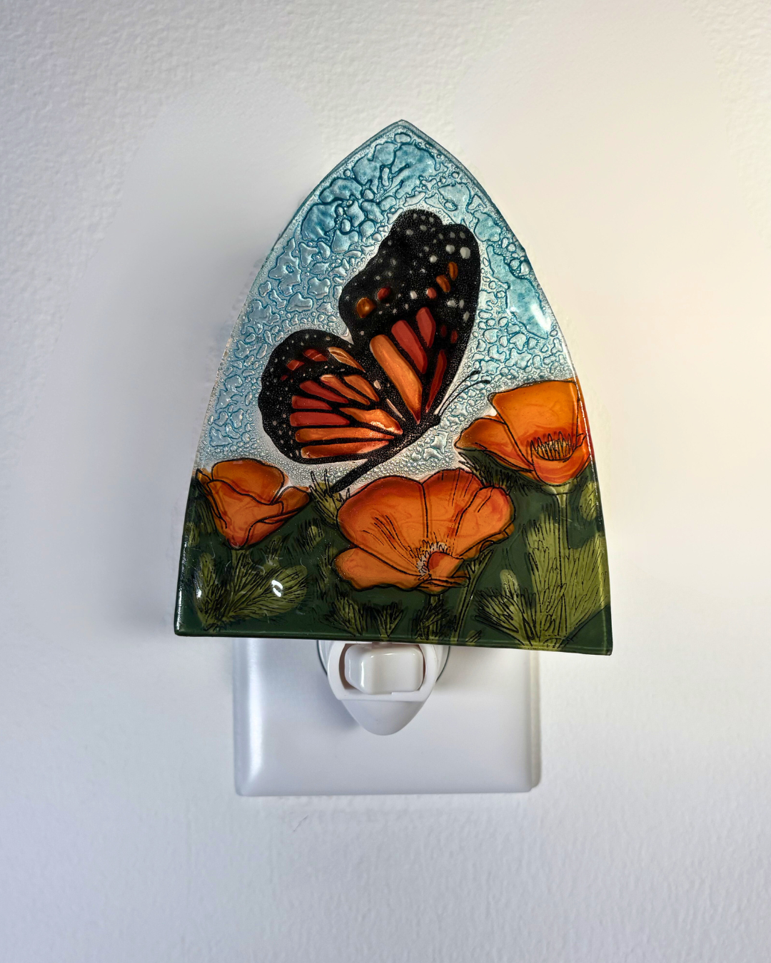 Decorative night light with butterfly and flower design on a white background