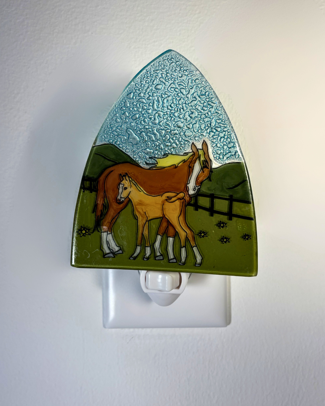 Nightlight with a design of two horses in a field on a white background