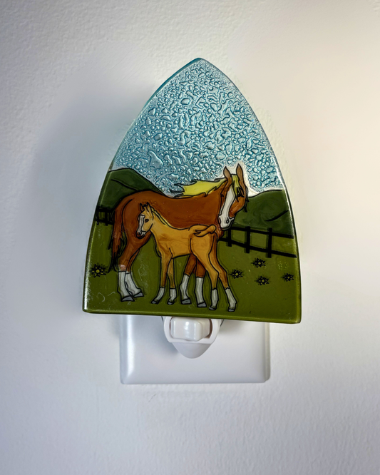 Nightlight with a design of two horses in a field on a white background