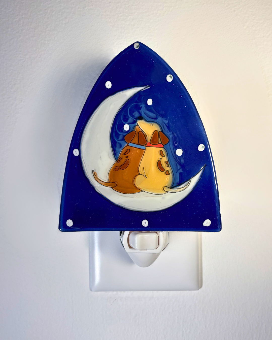 Decorative night light with a dog on a crescent moon design on a blue background.