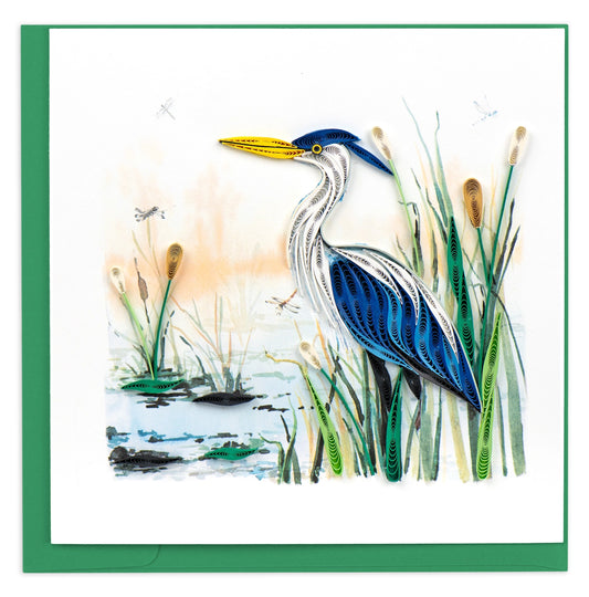 Greeting Card with a Great Blue Heron sits upon a rock along a stream surrounded lilypads and cattails.