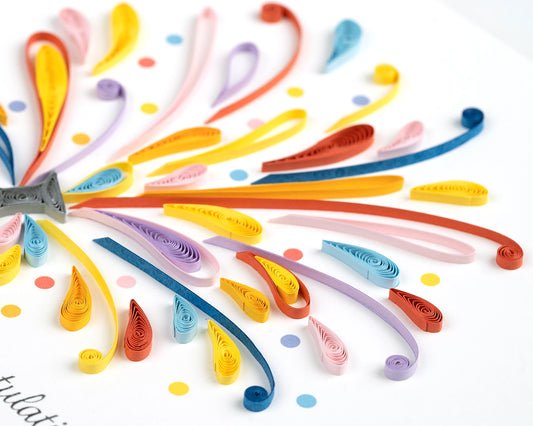 White Card with a bottle of sprays of quilling paper with congratulations below