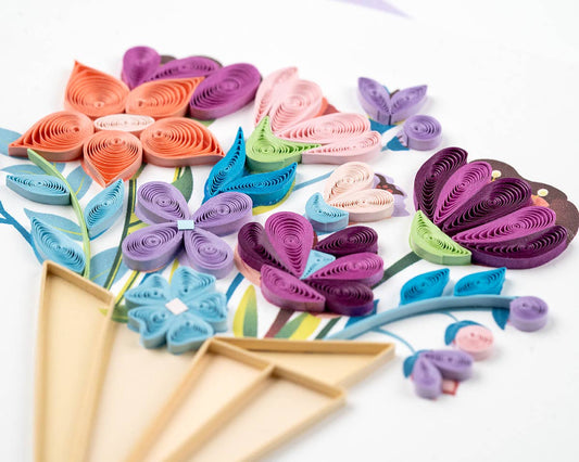 Close up of greeting card with quilled spirals of paper in different flower shapes all wrapped in a light brown bouquet.