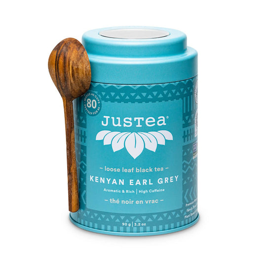 Justea Kenyan Earl Grey tea canister with a wooden spoon on a white background