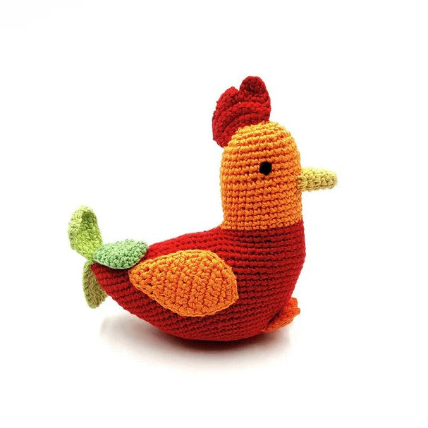 The profile view of a red and orange crocheted rattle baby toy.