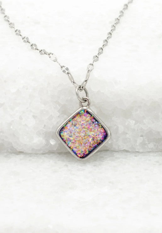 Silver necklace with a multicolor artifical opal square pendant on a white background
