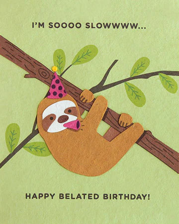 A belated birthday card featuring a cartoon sloth hanging from a tree branch with a party hat on, and text that reads 'I'M SOOOO SLOWWWW.