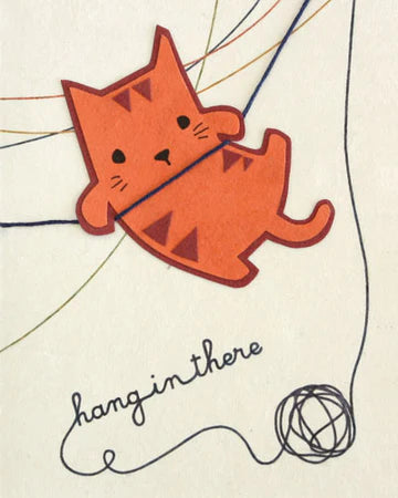 A greeting card with an illustration of an orange cat balanced on a thread, with the phrase 'hang in there' written at the bottom.