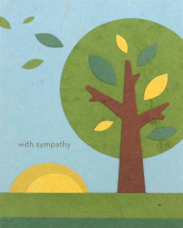 A greeting card with a simplistic illustration of a tree with green leaves and a yellow sun in the background. The text 'with sympathy' is printed on the card.
