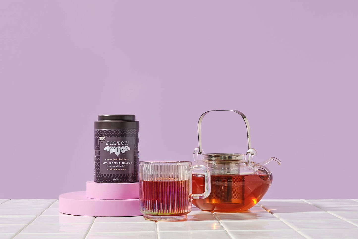 Tea packaging and teapot with tea on a light purple background