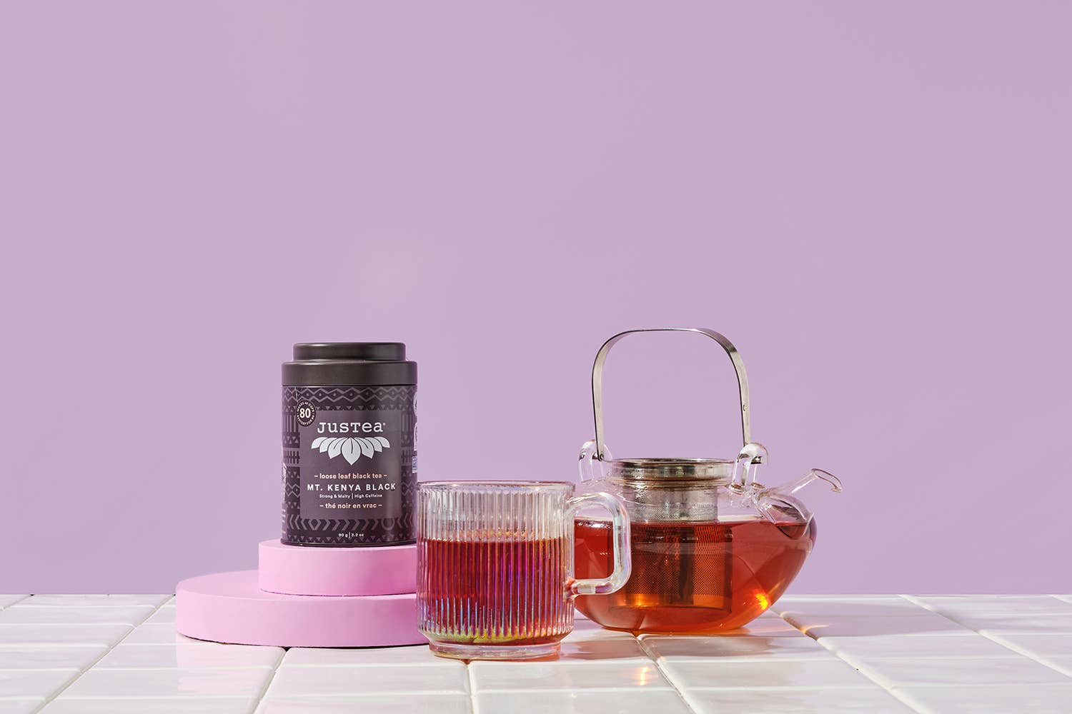 Tea packaging and teapot with tea on a light purple background