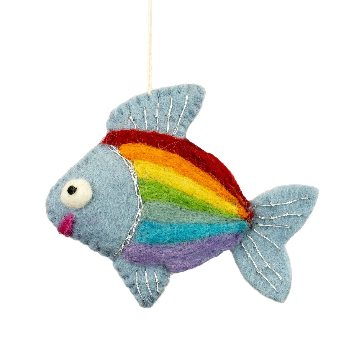 A handmade felt fish ornament in light blue with a rainbow stripe pattern in red, orange, yellow, green, blue, and purple, hanging from a white string against a white background.