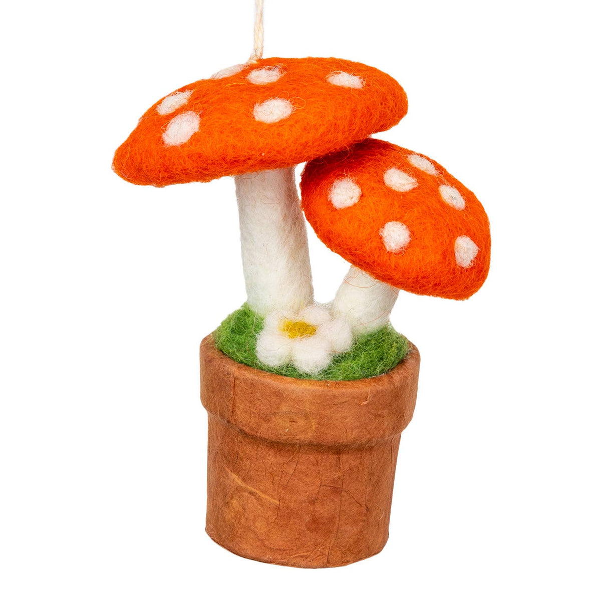A felt mushroom ornament hanging from a string, featuring two bright orange mushrooms with white spots, white stems, green grass, and a brown pot on a plain white background.