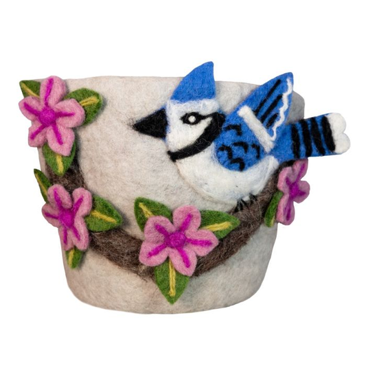 A white felted planter decorated with a blue jay bird and pink cherry blossom flowers on a branch, set against a plain white background.