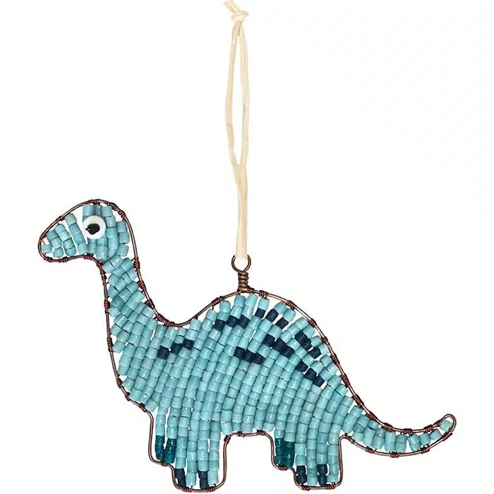 A mosaic dinosaur ornament shaped like a long-necked sauropod, made from light blue and dark blue glass tiles with a white eye detail, hanging from a cream-colored string against a plain white background.