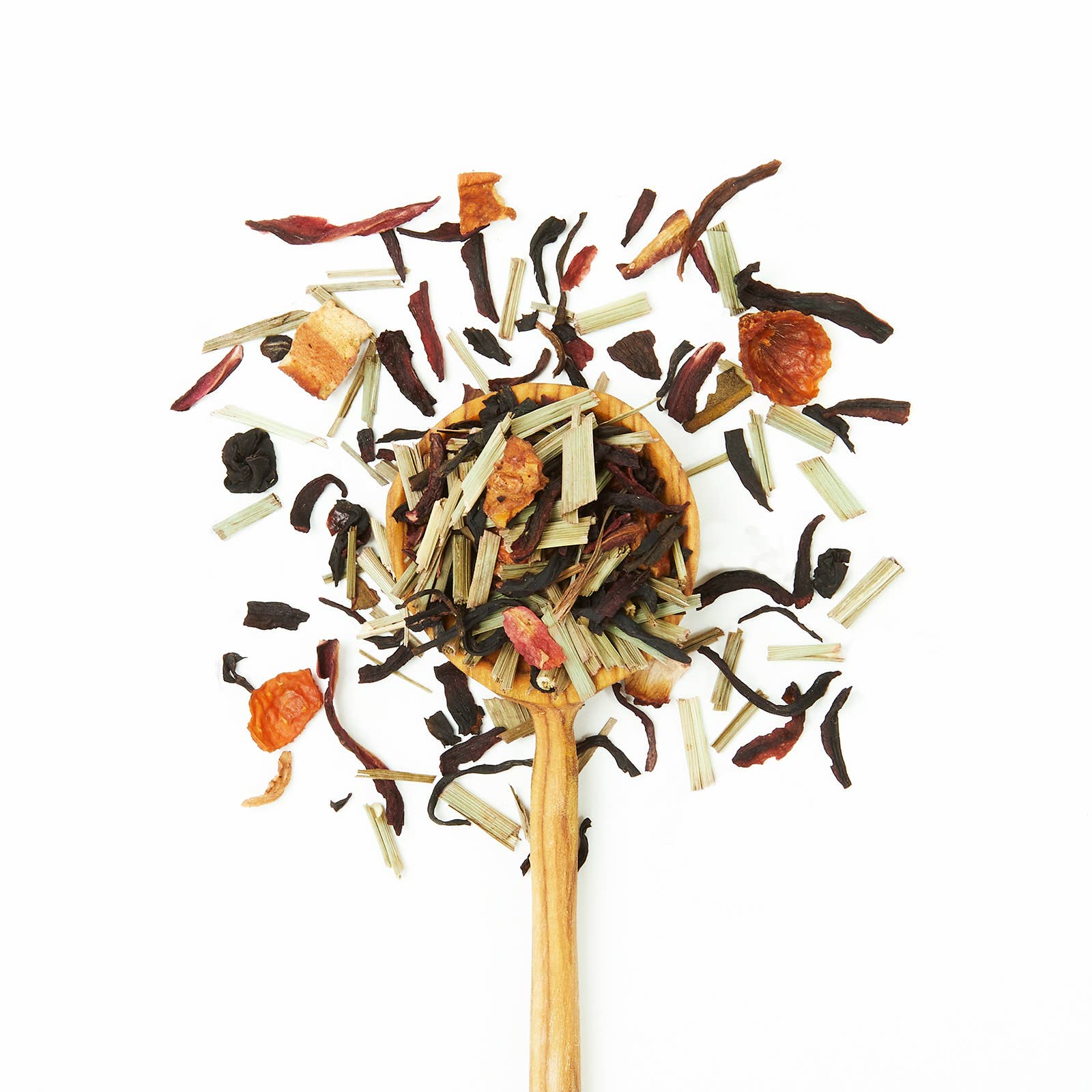 Wooden spoon filled with a mix of dried tea leaves on a white background