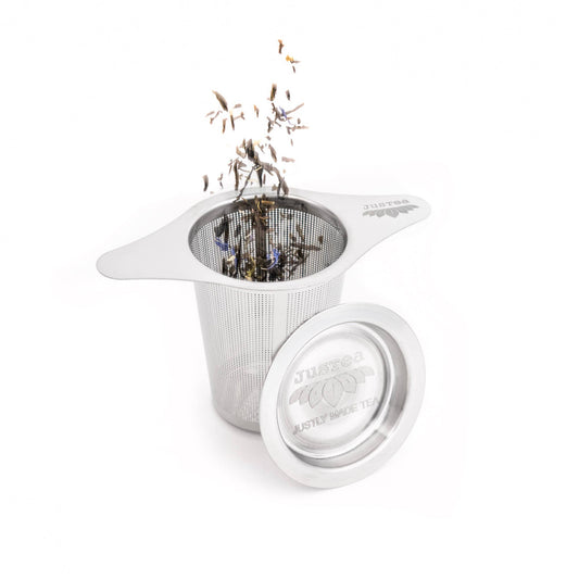 Stainless steel tea infuser with loose leaf tea on a white background