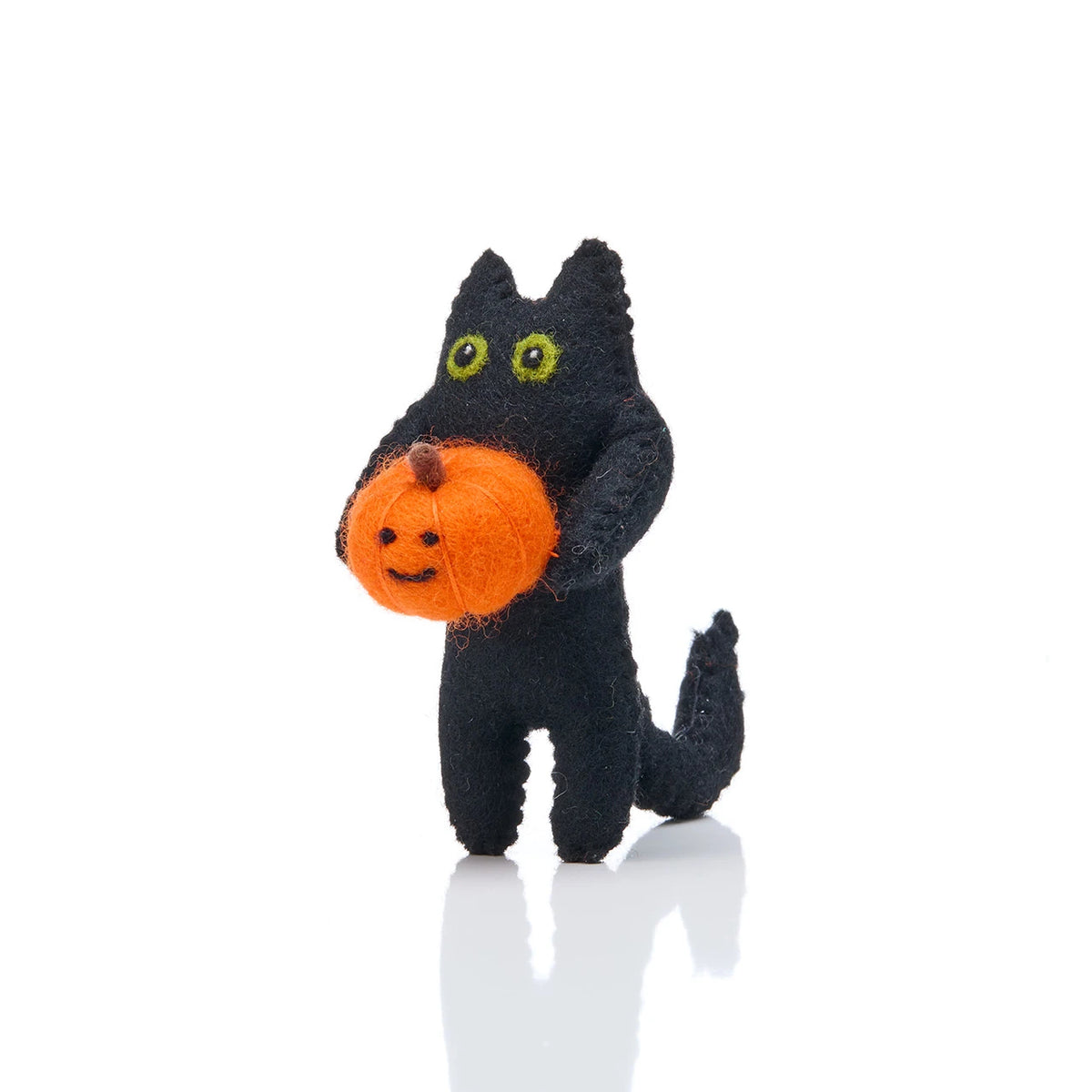 Stuffed black cat holding an orange jack o lantern on a white background
