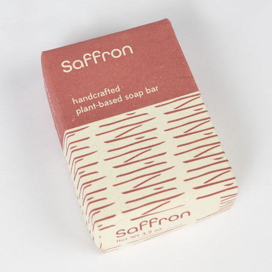A red and tan geometric package that says "Saffron" is laid on a pain white background.