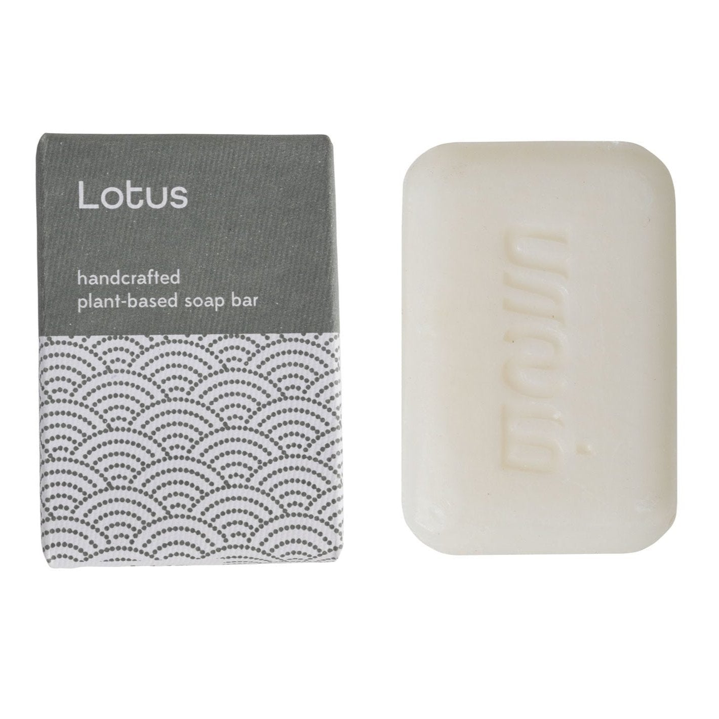 A bar of soap and blue and white package with a label that reads 'LOTUS Handcrafted Plant Based Soap Bar.'