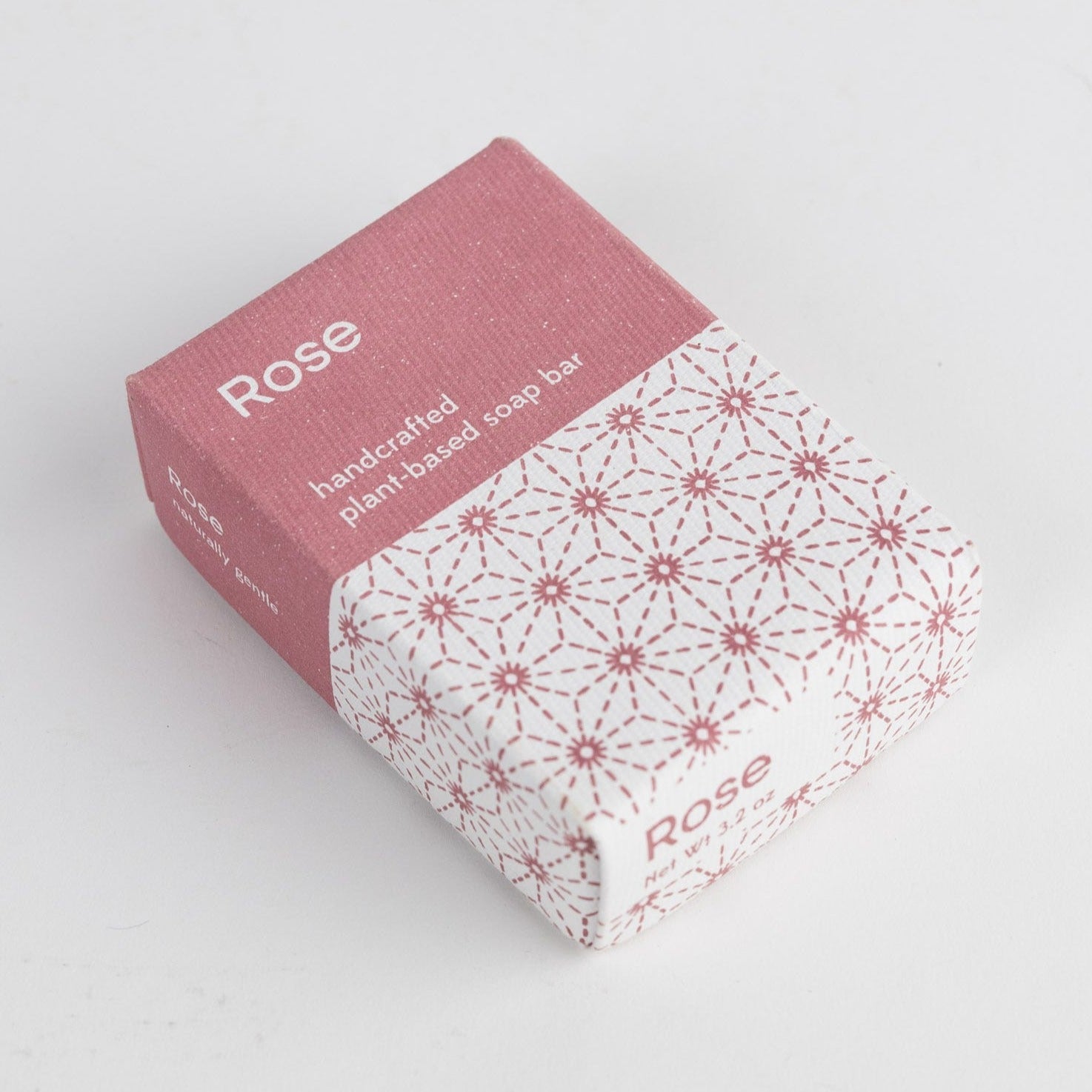 A pink and white box with the word "Rose" and "handcrafted plant-based soap bar" written across it.