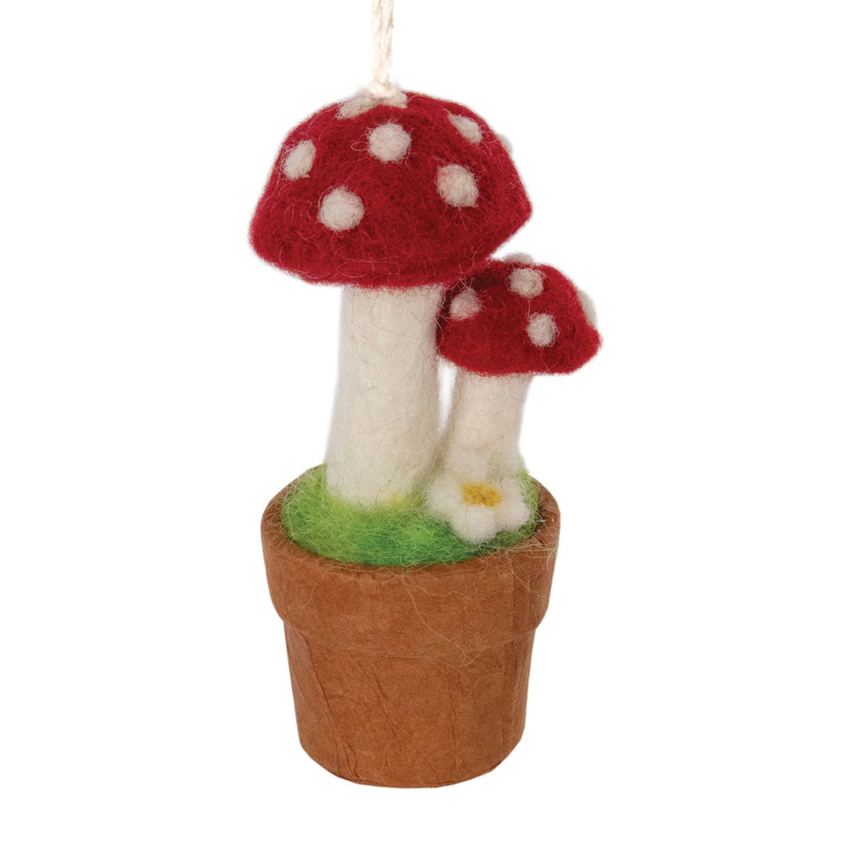 A felted wool mushroom ornament hanging from a white string, featuring two red and white spotted mushrooms in a brown pot with green grass, set against a plain white background.