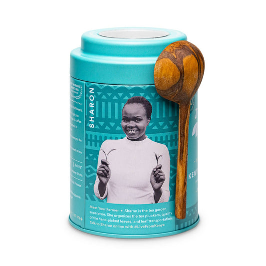 Back of teal tea canister with wooden spoon featuring a photo of a Kenyan tea farmer.