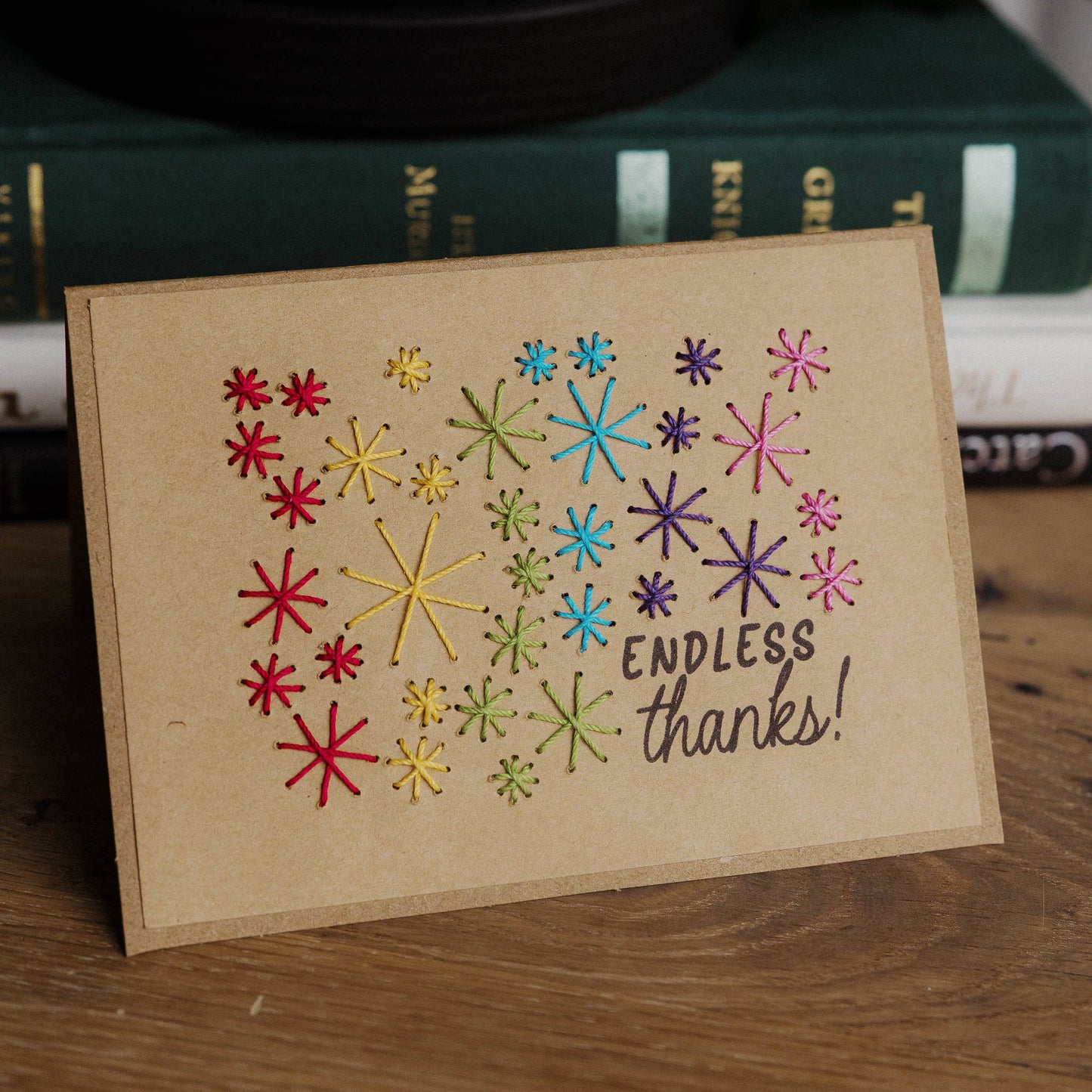 Card with colorful star patterns and 'Endless thanks!' text on a wooden surface.
