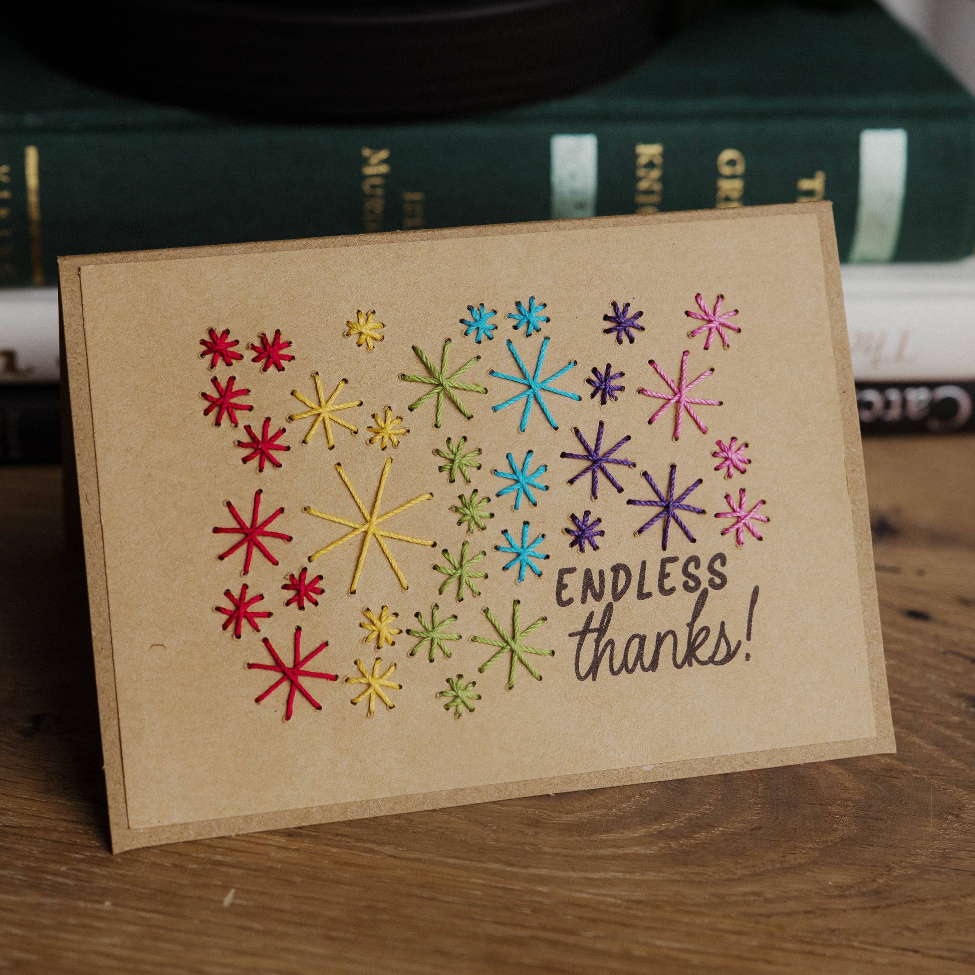 Card with colorful star patterns and 'Endless thanks!' text on a wooden surface.