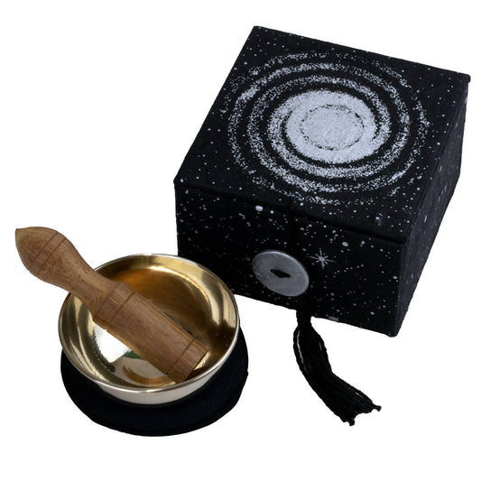 Tibetan singing bowl set with wooden striker and black box featuring celestial design on a white background