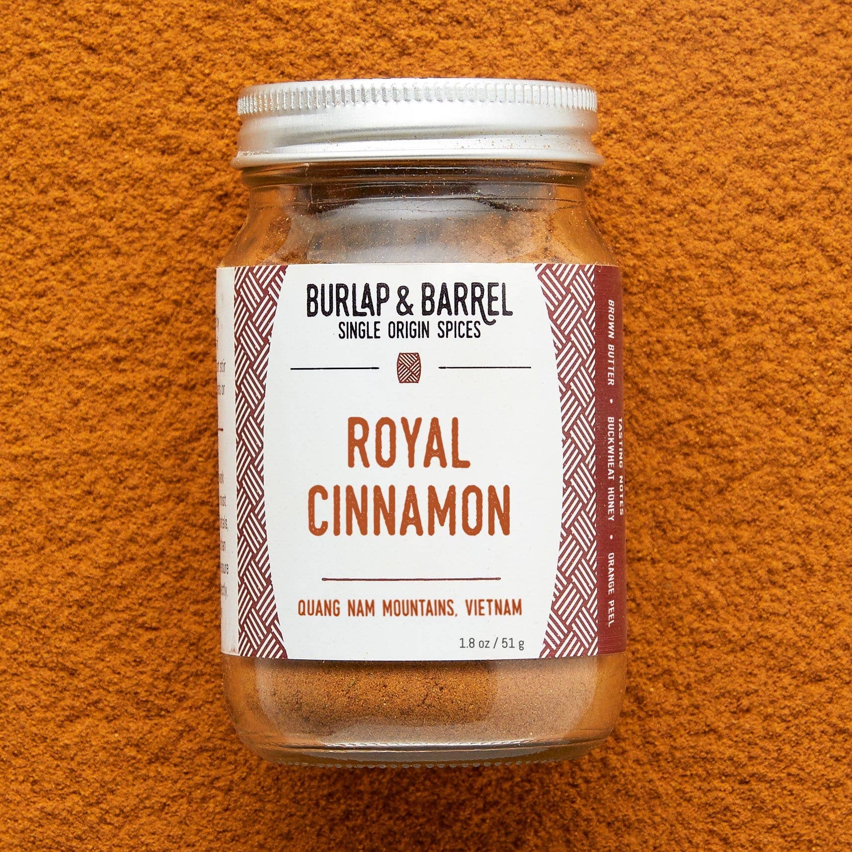 Jar of Burlap & Barrel Royal Cinnamon on an orange background