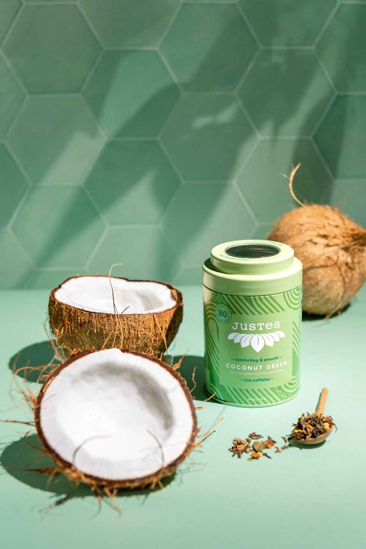 Green tea tin labeled 'Justea' with coconuts on a green background