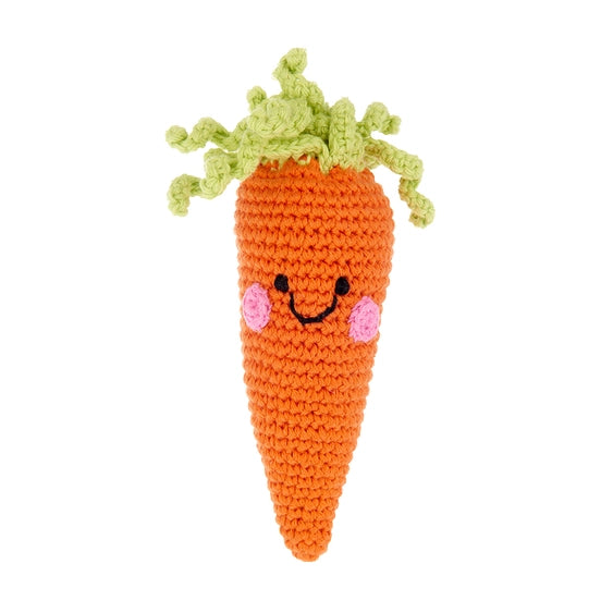 A crochet rattle in the shape of a carrot with a smiling face and green leafy tops.