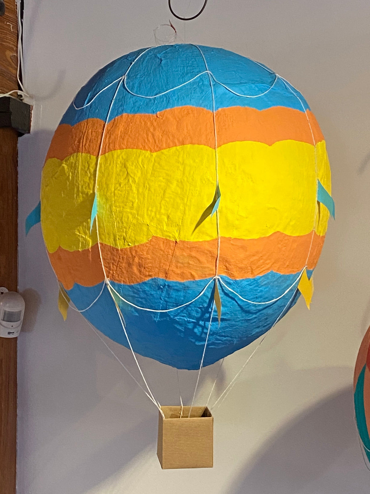 Blue, orange, and yellow banded plaster of paris hot air balloon.
