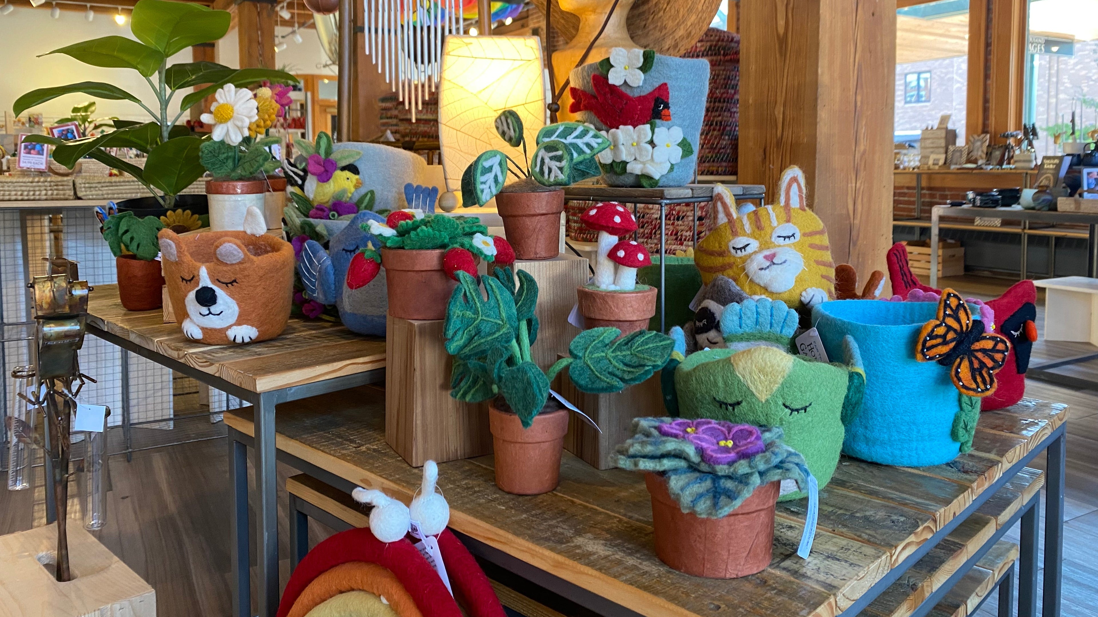 Display of decorative felt plant pots and other garden themed items in a store setting.