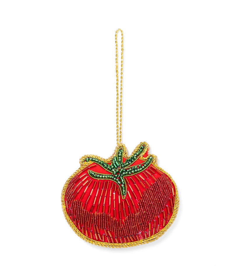 Red tomato ornament covered in detailed beadwork with embroidered green leaves and a metallic gold hanging loop.