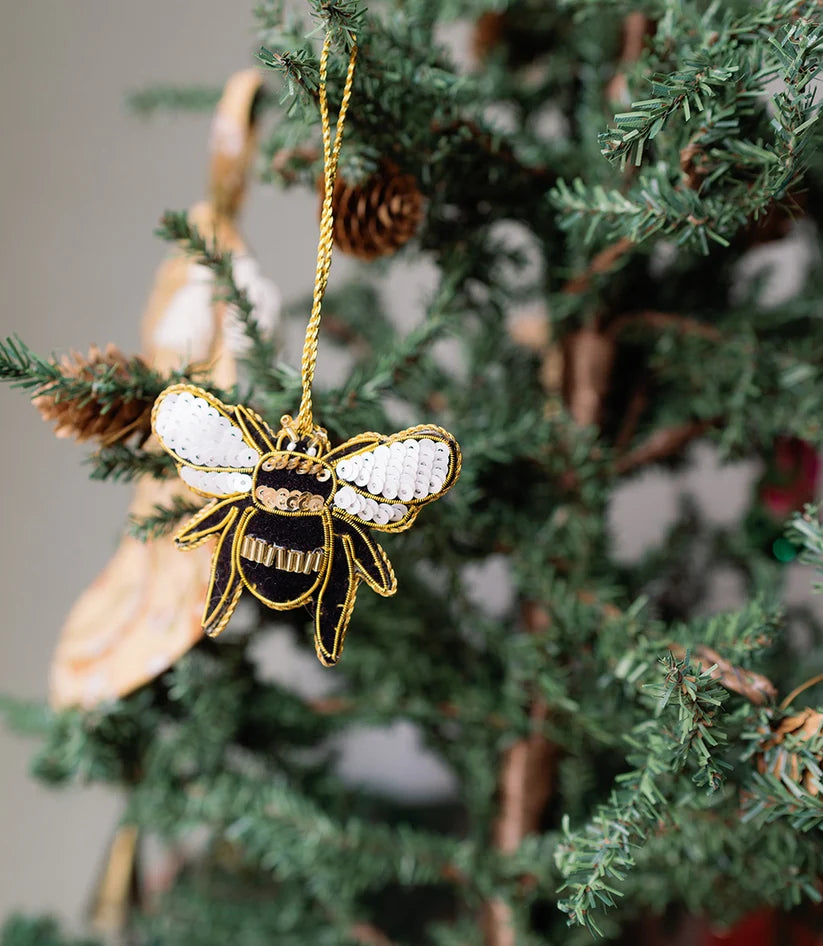 Close-up of a handcrafted bee ornament showing vibrant beads and detailed embroidery.