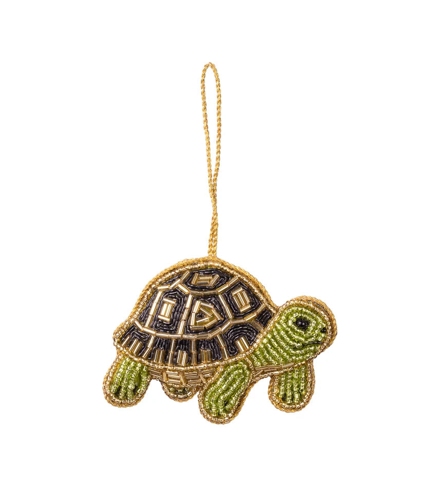 Green turtle ornament embellished with gold, black and green glass beads with a gold hanging loop.