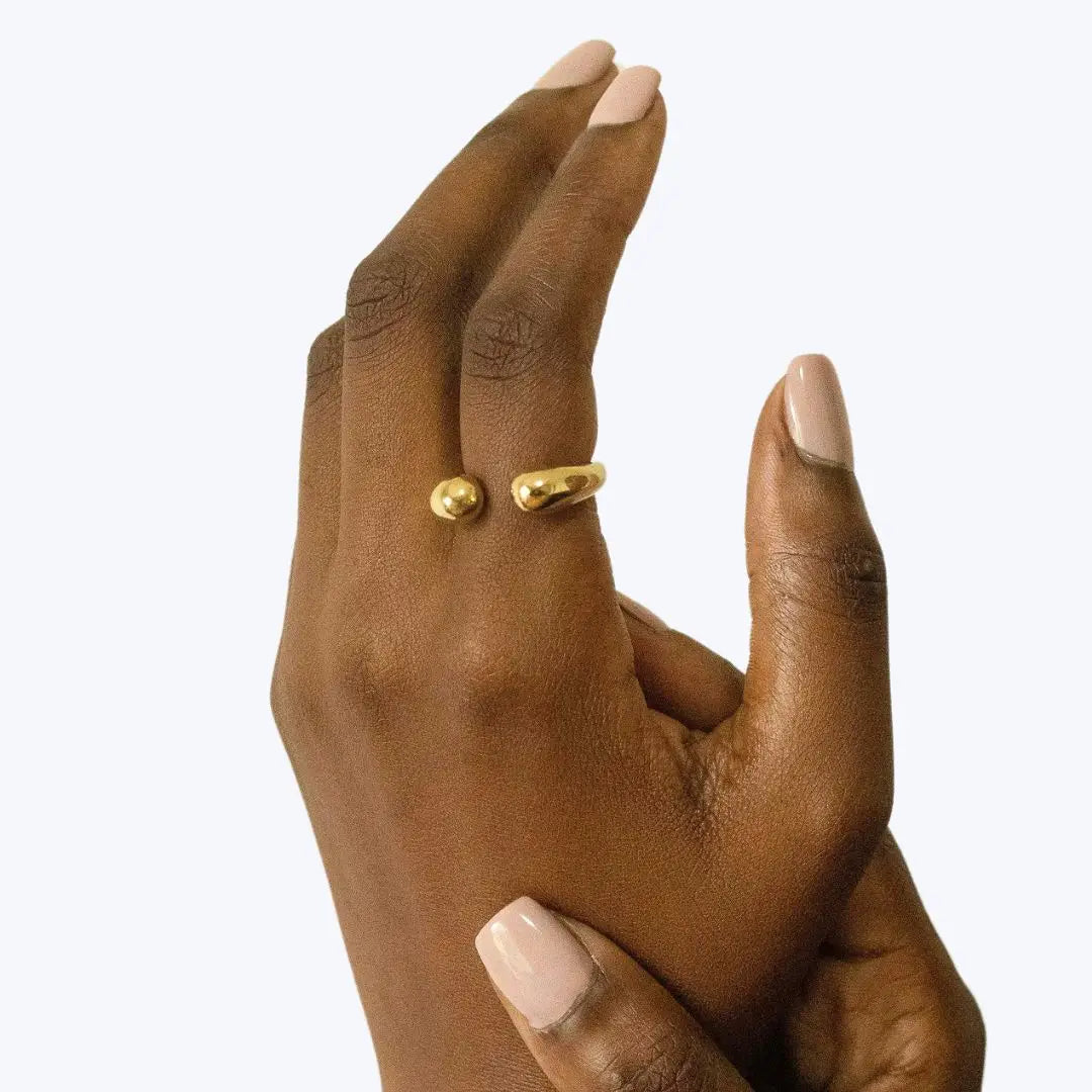 Gold ring on a person's finger against a white background