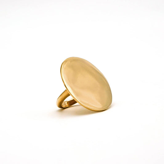 Gold ring with a flat, oval-shaped top on a white background