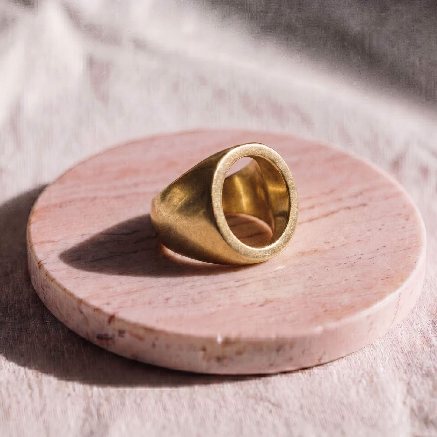 Gold ring on a pink stone surface